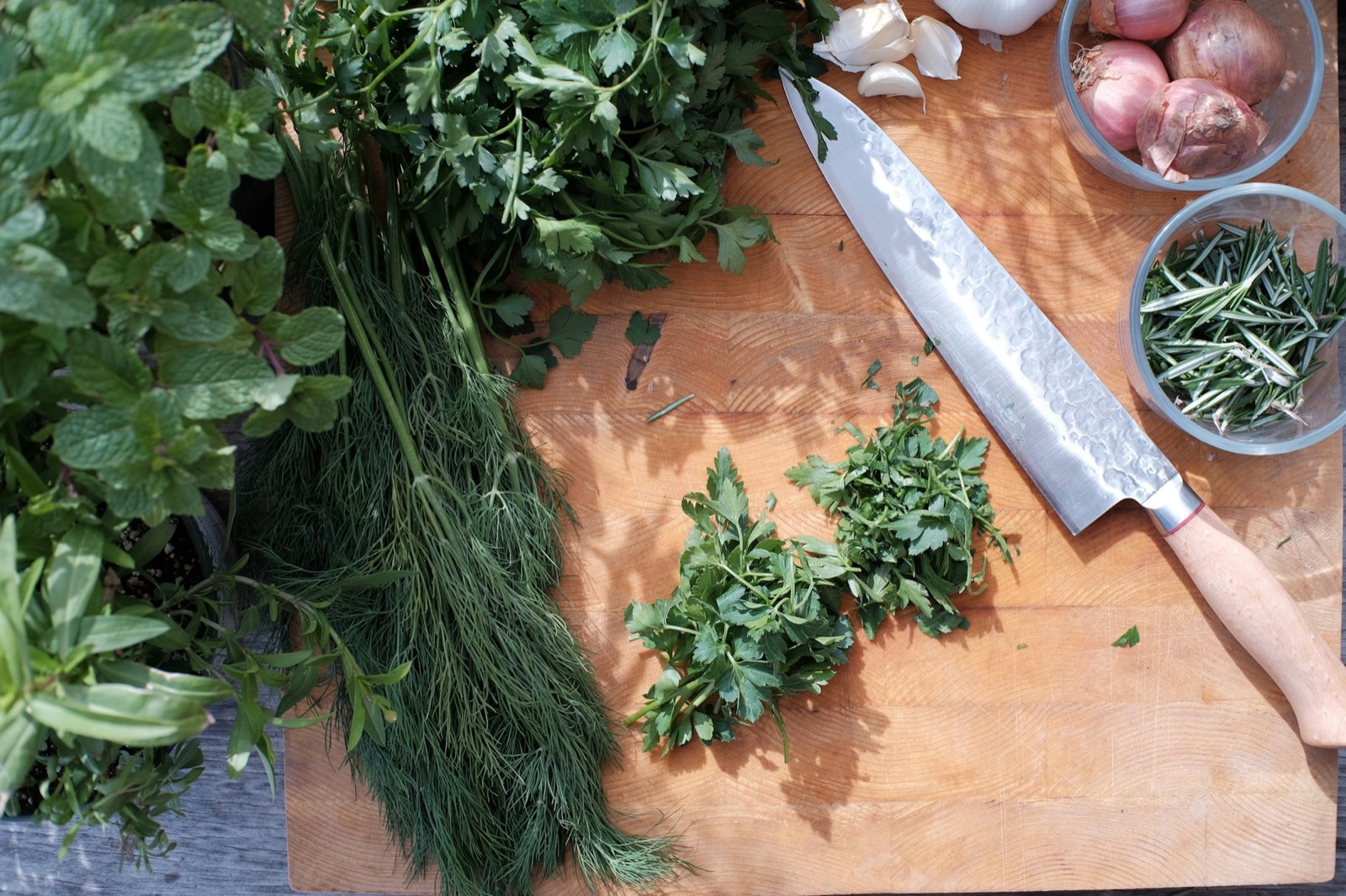 Fresh herbs and a knife on a wooden board